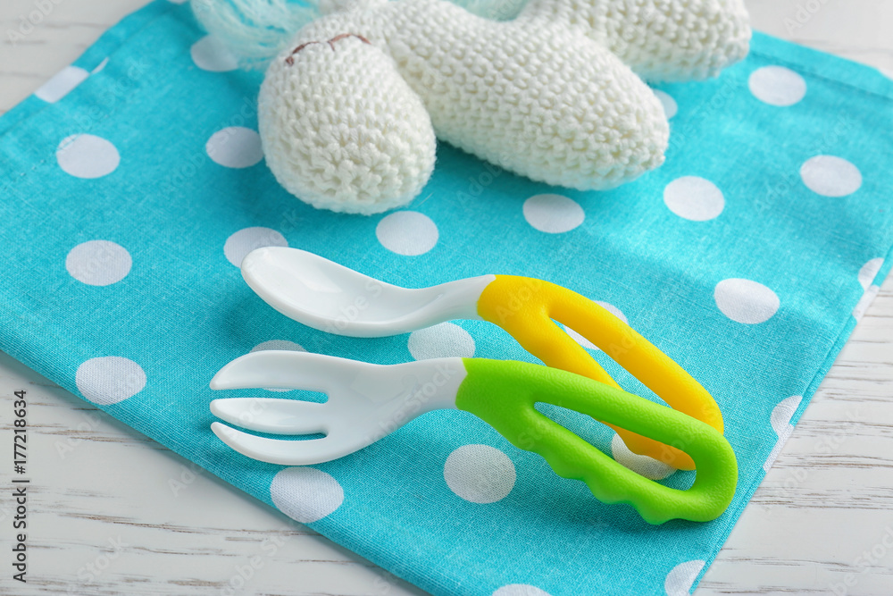 Colorful plastic eating utensils for baby on table