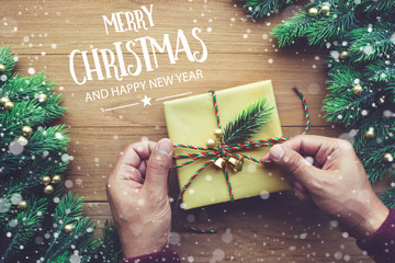 Wall Mural - merry christmas and happy new year typography,text with human hand decorating gift box presents and 