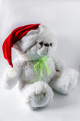 toy teddy bear wearing santa hat, on a light background.