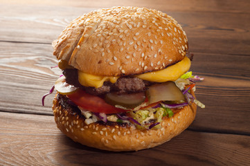 Street food - big burger on a wooden background, close-up