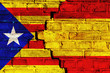 Catalonia independence movement versus Spain central government: symbolic for ongoing dispute on separation and autonomy. Flags of Catalan separatism and Spanish flag painted on cracked brick wall