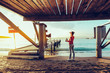 © tinyakov - Beautiful Young Woman With Binoculars In Hand Standing By The Sea Near Pier And Enjoying View Of Nature