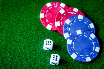 poker chips and dice on green background top view