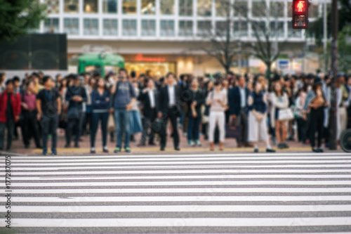 Fototapeta Zamazani ludzie chodzi przez Shibuya skrzyżowanie z pośpiechu tłumami w ulicie, JAPONIA Shibuya.