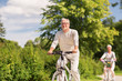 © Syda Productions - happy senior couple riding bicycles at summer park