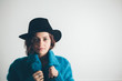 © kkgas/Stocksy - Portrait of a beautiful young woman in a hat and blue coat