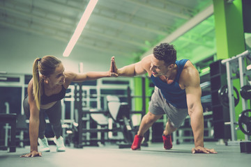 The man and woman doing push up exercise and gesture in the gym