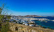 Panoramic view over the town of Mykonos Island in Greece at sunny day with the stone wall on the foreground