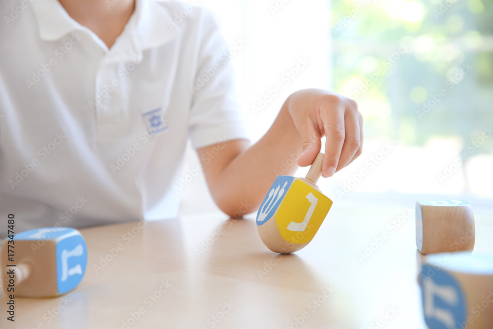 Jewish boy playing with dreidel at home