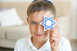 Boy holding Star of David at home