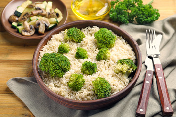 Canvas Print - Bowl with brown rice and broccoli on table