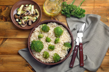 Canvas Print - Composition with bowl of brown rice and broccoli on table