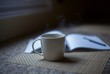 © Carolyn Lagattuta/Stocksy - Cup of steamy hot coffee with a notebook beside it