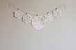 © Kerry Murphy/Stocksy - Paper snowflake cutouts hanging from string on wall