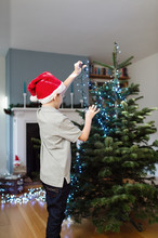 Child Decorating His Christmas Tree With Lights