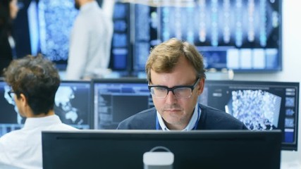 Fototapete - Neural Network Algorithm Architect Working at His Workstation in a Busy Creative Office. Multi-Ethnic Team Works with Multiple Screens Showing AI, Data Mining, Machine Learning Processes.