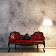 Nostalgisches rotes Sofa mit Verzierungen vor Betonwand mit Stehlampe auf Holzboden