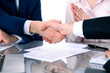 © rogerphoto - Business people shaking hands finishing up a meeting