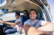 © AlejandroMCB/Stocksy - Group of three young men driving an SUV car on a road trip through the desert on adventure travel