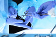Surgeons hands holding surgical scissors and passing surgical equipment, close-up. Health care and veterinary concept