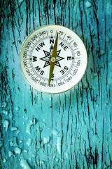 compass on old wood table with water drops, find the right direction concept, flat top view