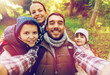 © Syda Productions - family with backpacks taking selfie and hiking