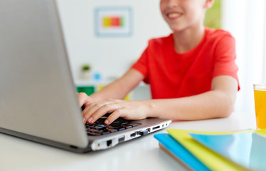 Canvas Print - student boy typing on laptop computer at home