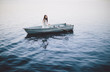 © HOWL/Stocksy - Lonely girl floats alone in a row boat on a foggy New England morning.