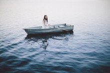 Lonely Girl Floats Alone In A Row Boat On A Foggy New England Morning.