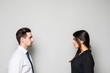 © F8  \ Suport Ukraine - Concept of confrontation in business. Close up photo of two young serious confident people standing face-to-face to each other on gray