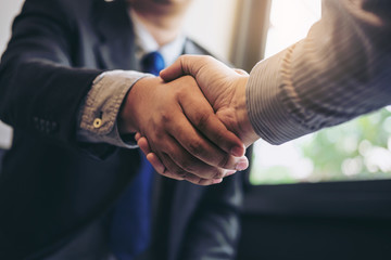 Fototapete - Two business men shaking hands during a meeting to sign agreement and become a business partner, enterprises, companies, confident, success dealing, contract between their firms