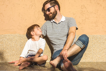 Wall Mural - The happy man and the son sit near the house