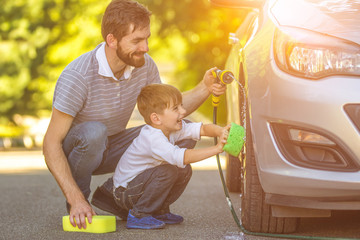 Wall Mural - The happy boy and the father washing a car outdoor