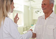 © dream@do - Smiling female doctor giving handshake to senior male patient. Health care concept