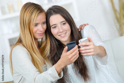 Plakat dwie przypadkowe dziewczyny oglądające promocje na linii komórkowej