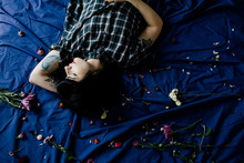 Beautiful Tattoo Woman Sleeping On The Bed Full Of Flowers
