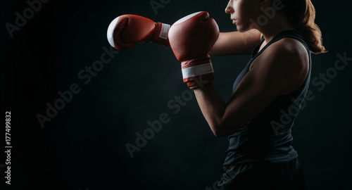 Plakat Żeński bokser z czerwonymi bokserskimi rękawiczkami, czarny tło z kopii przestrzenią