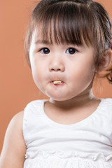 Wall Mural - Cute baby girl eating biscuit