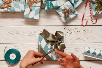 Wall Mural - Woman wrapping christmas presents over wooden background