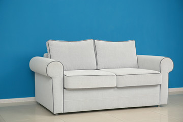 Sticker - Comfortable sofa on color wall background