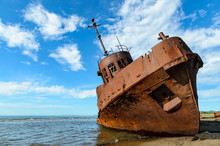 Rusty Shipwreck On The Shores Of Beach
