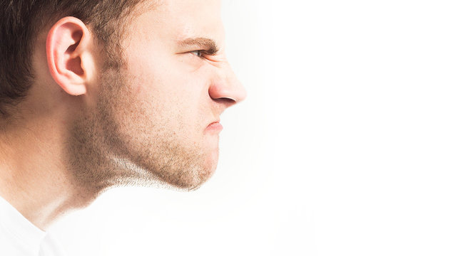 Fototapete - disgruntled, angry face of a man on a white background in profile