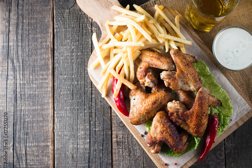 Zdjęcie XXL Zakończenie fotografia bbq kurczaków skrzydła z fries i piwem. Mięso z grilla z sosami, ketchupem, majonezem. Koncepcja fast and fast-food.