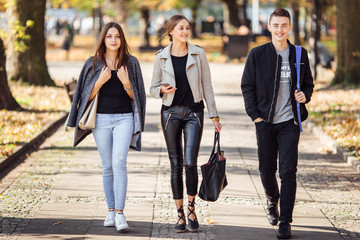 Three friends walk on the street