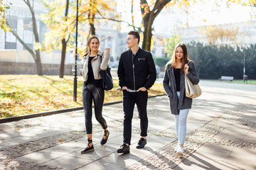 Three friends walk on the street