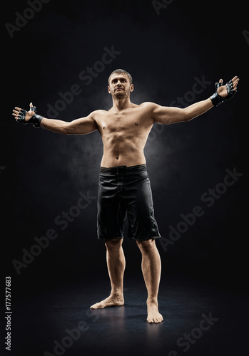 Zdjęcie XXL mma mężczyzna wojownik stojący z rękami w górę na białym tle