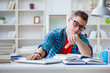 © Elnur - Young teenager preparing for exams studying at a desk indoors