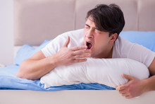 Man Suffering From Insomnia Lying In Bed