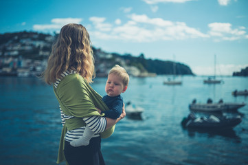 Wall Mural - Young mother with baby by seaside village