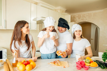 Happy family eating pizza on the wooden table